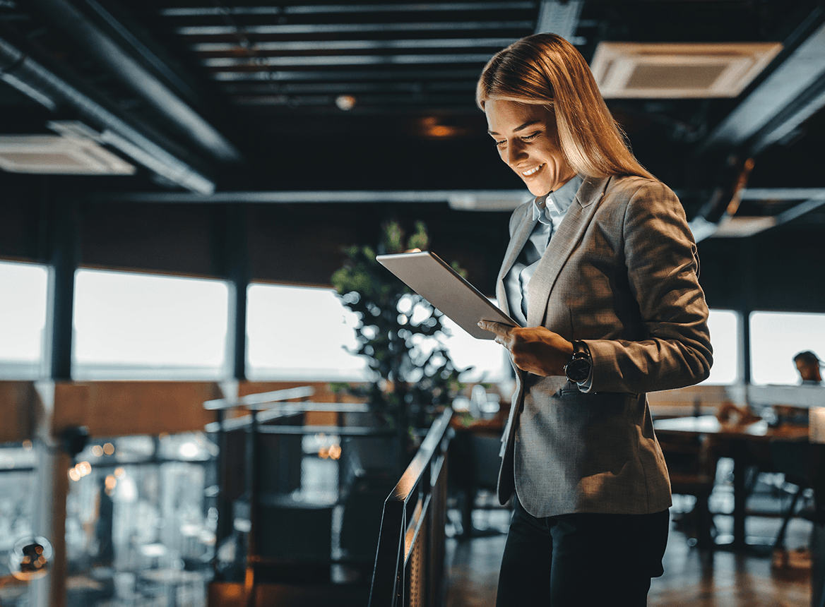 Blonde Woman Smiling and Looking at Tablet