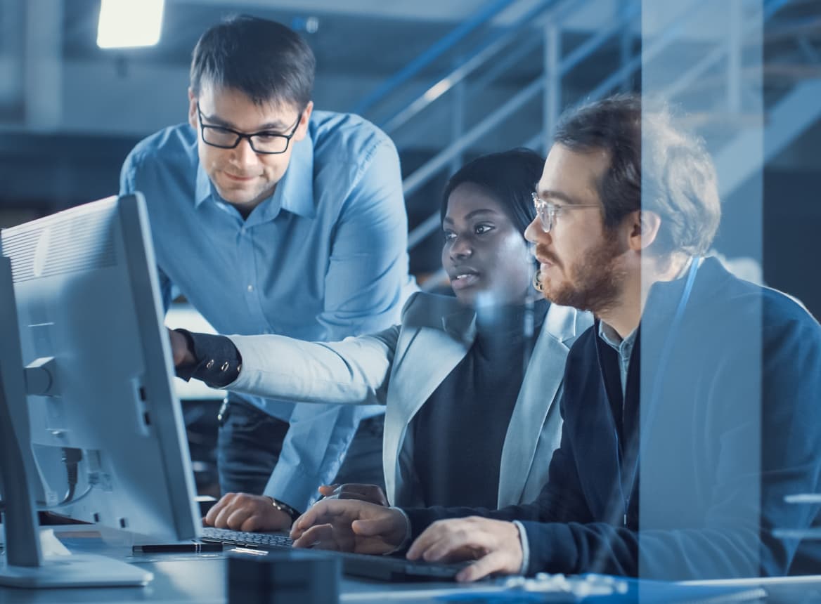 A Woman Pointing at a Computer While Two Men Look
