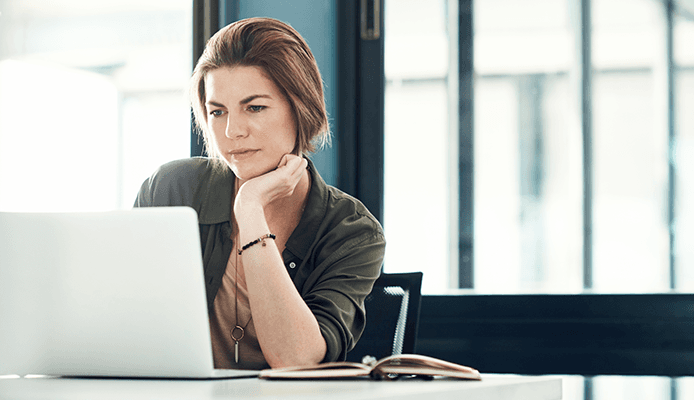 Woman looking at laptop screen in home office