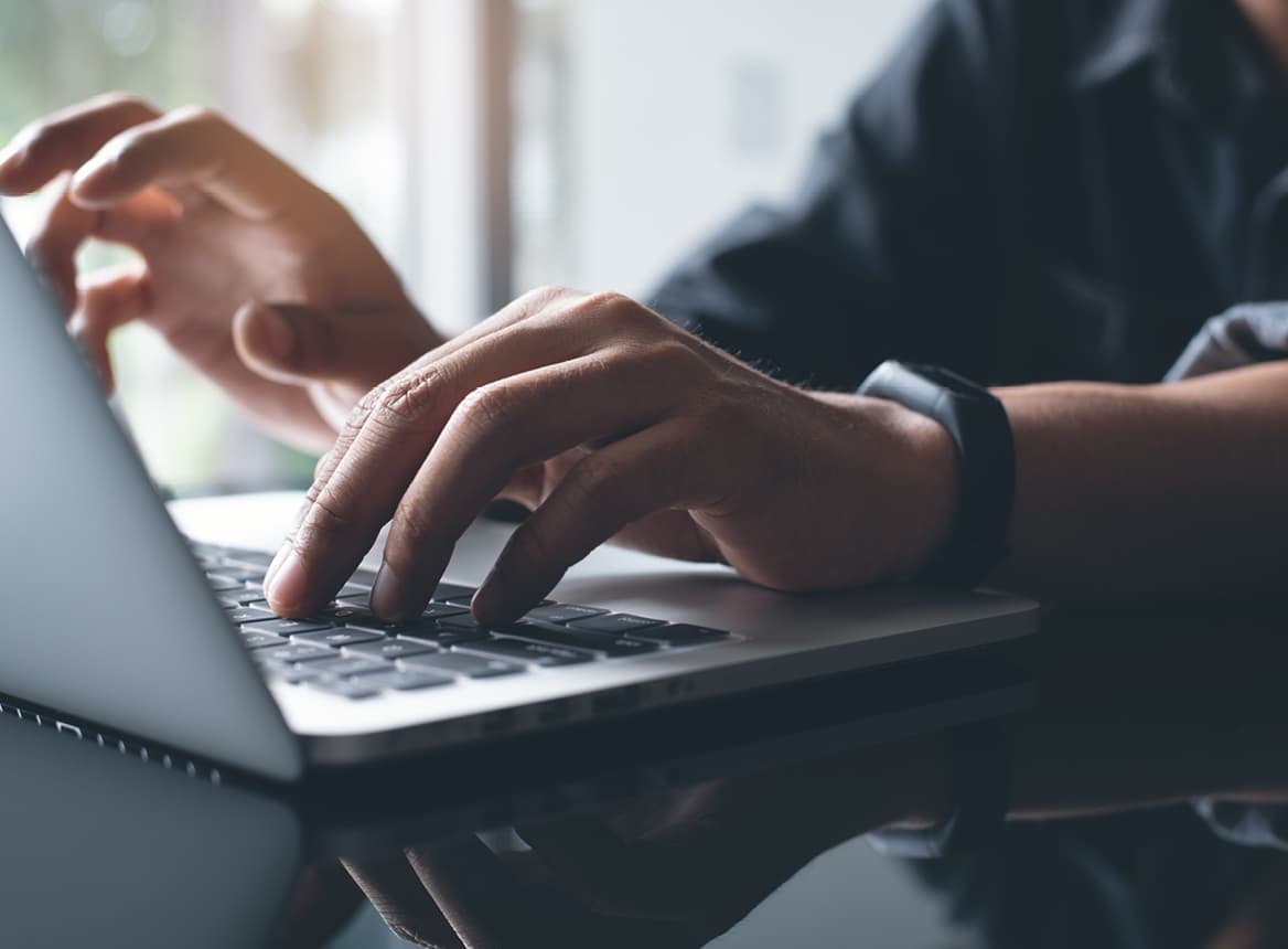 Close Up of Man Wearing a Watch and Typing on Laptop