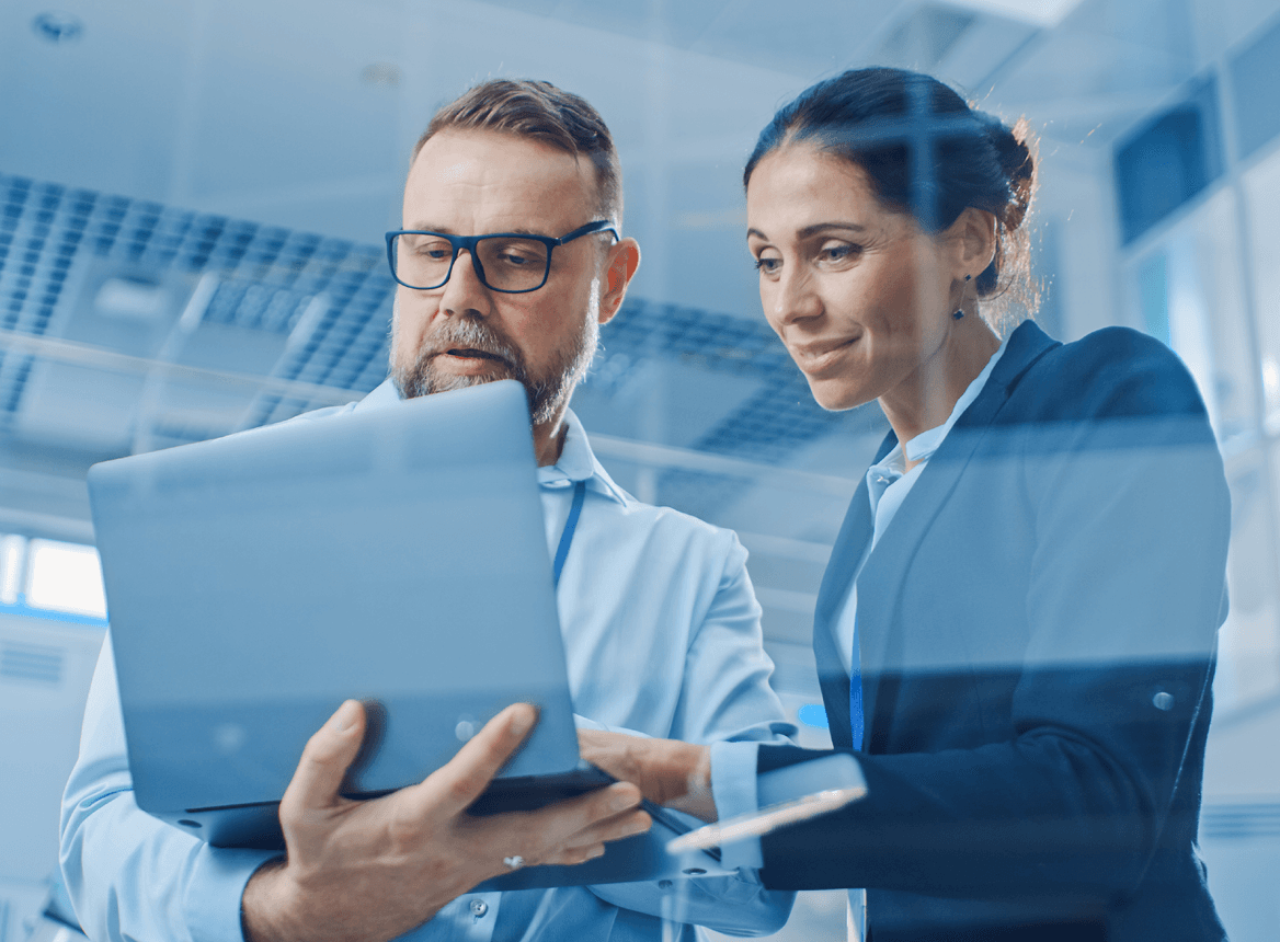 A Man and Woman Looking at a Laptop in Business Setting