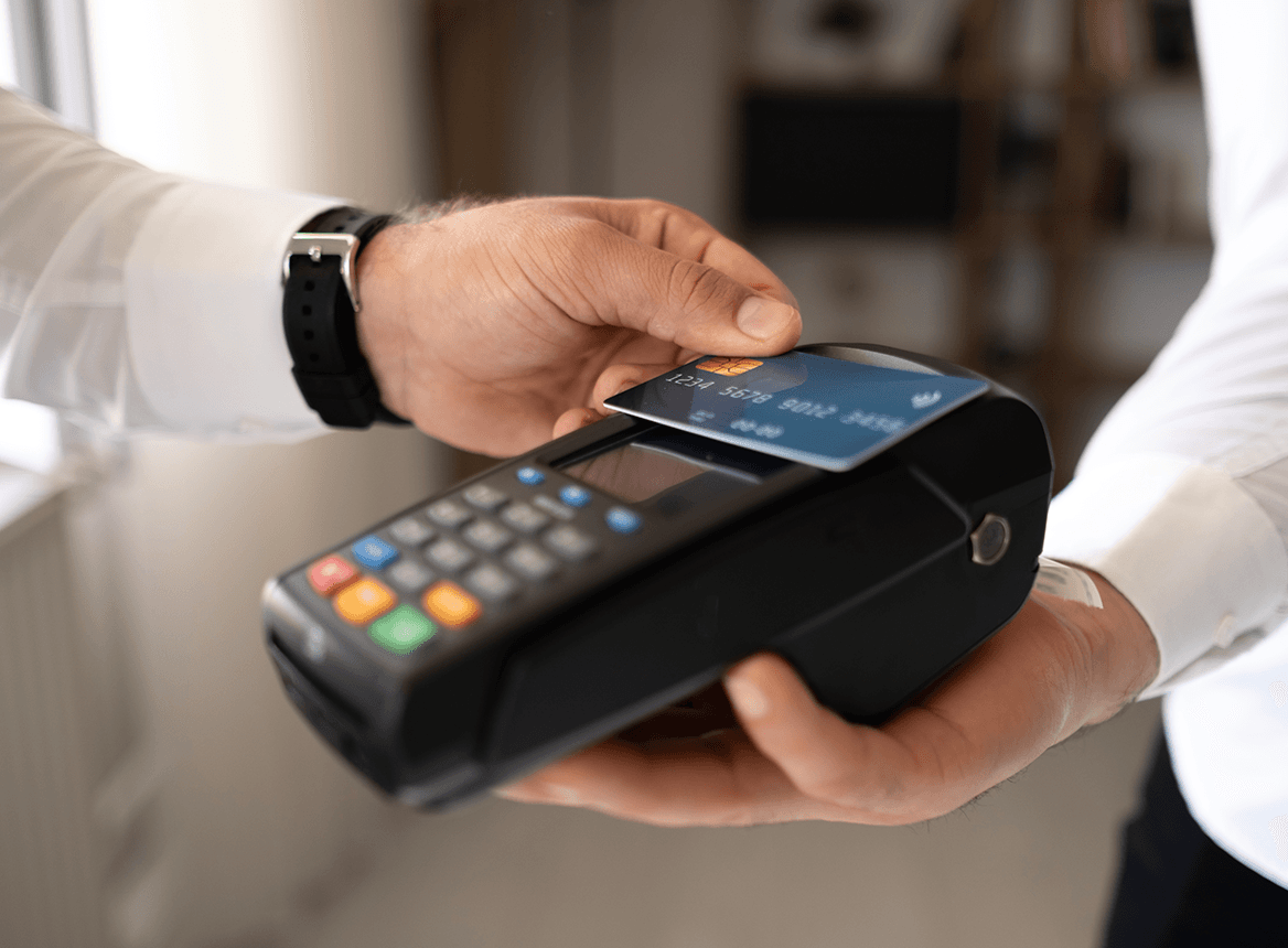 Close Up of Person Tapping Their Credit Card on Machine Reader
