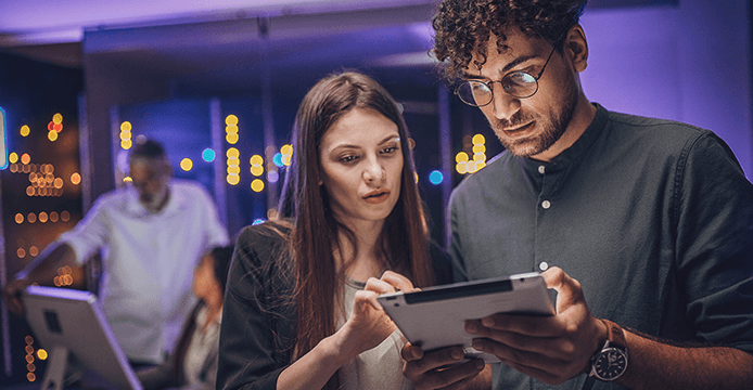Two people working on a tablet device
